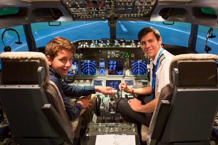 a group of people sitting at a desk in front of a car